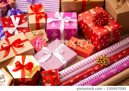 Background of bright Christmas presents, some wrapping paper in the corner. Christmas concept 130997090