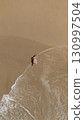 Pregnant Woman Relaxing by the Ocean Aerial Beach Photography 130997504