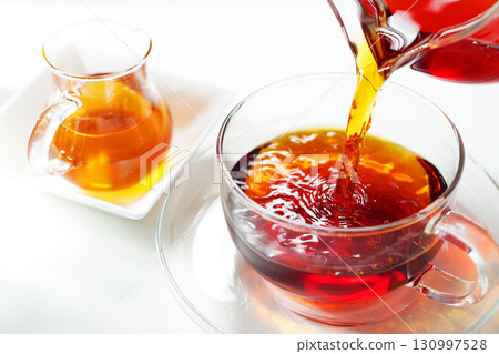 Honey tea poured into a teacup 130997528