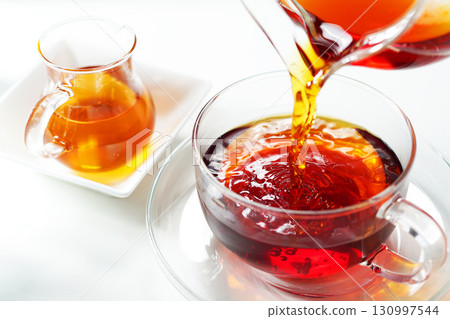 Honey tea poured into a teacup 130997544