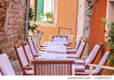 Cafe tables on narrow European streets 130997833