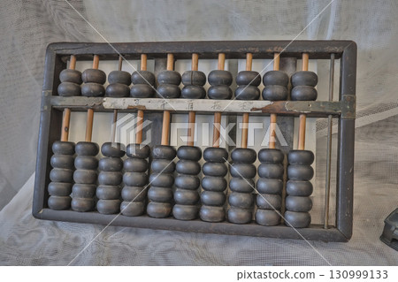 Sept 13 2025 Vintage Wooden Abacus with Dark Beads on Mesh Textile Background 130999133