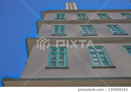 Sept 13 2025 Facade of a Modern Building with Blue Windows Against a Bright Sky 130999162