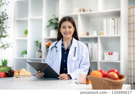 Dietitian Consultation. Happy healthcare professional ready to assist patients with nutrition. Dietitian Consultation. Happy healthcare professional ready to assist patients with nutrition. 130999817