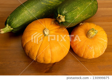 Pumpkins and zucchini representing autumn harvest vegetables on wood Pumpkins and zucchini representing autumn harvest vegetables on wood 130999875