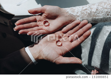 Couple Holding Wedding Rings in Palms 131000851