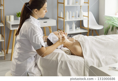 Woman having facial cleaning procedure during visit at beauty center or spa salon 131000886