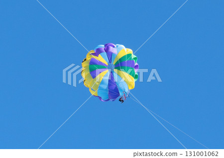 Parasailing on a sunny day. Parachuting above the clouds. Parasailing in a blue sky. Parachute walk on the sea 131001062