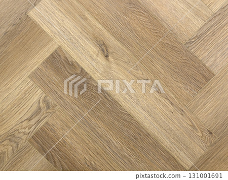 Laminated wood floor. Empty room with floating laminate in new apartment. Dark walnut chevron surface. Premium oiled oak parquet texture. 131001691