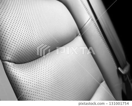 Car black leather interior. Part of black leather car seat details with white stitching. Interior of prestige car. Perforated leather seats isolated. Perforated leather. Car black leather interior. Part of black leather car seat details with white stitching. Interior of prestige car. Perforated leather seats isolated. Perforated leather. 131001754
