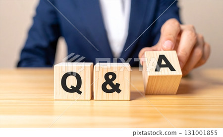 Businessman holding Q&A blocks 131001855