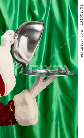 Hand lifting cloche with serving tray on festive background Hand lifting cloche with serving tray on festive background 131002501