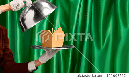 Blank food delivery box on silver tray revealed by waiter hand in white glove 131002512