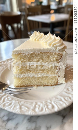 Piece of Cream cake on a white plate with a fork in the background. Piece of Cream cake on a white plate with a fork in the background. 131003294