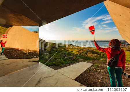 Andoya island sea coast and tourist with norwegian flag 131003807