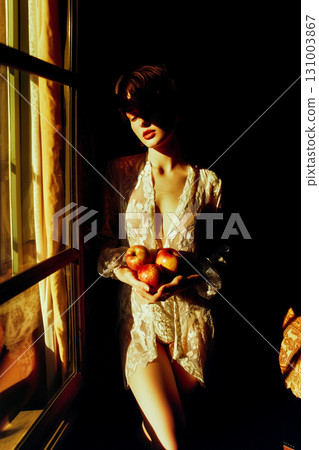 A woman is holding three apples in her hand 131003867