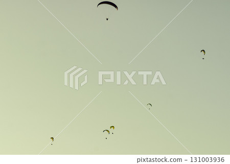 Paragliders flying in sky. Paragliders flying in sky. 131003936
