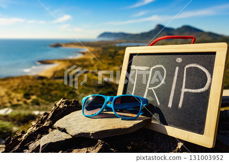 Black board with word trip against sea coast Black board with word trip against sea coast 131003952