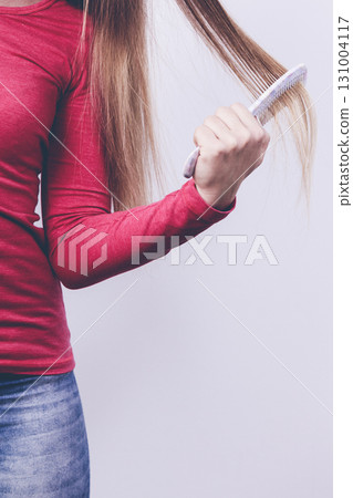 Woman combing her hair. 131004117