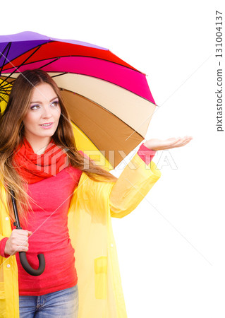 Woman in rainproof coat under umbrella 131004137