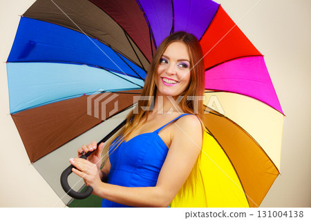 Woman in summer dress holds colorful umbrella 131004138