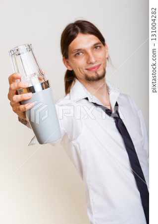 Young man with shaker making cocktail drink 131004282