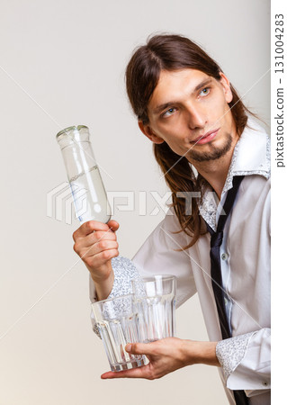 Bartender fills glass from bottle. 131004283