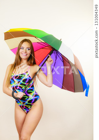 Happy woman posing in swimsuit and colorful umbrella 131004349