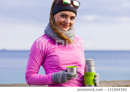 Fit woman in cold day warming up drink tea Fit woman in cold day warming up drink tea 131004392
