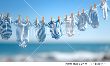 Blue striped baby clothes drying on a clothesline 131004558