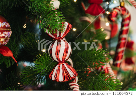 Festive shiny Christmas Tree with red and white striped baubles as sweet candy. Xmas holiday festivities and celebration. Close up. Festive shiny Christmas Tree with red and white striped baubles as sweet candy. Xmas holiday festivities and celebration. Close up. 131004572
