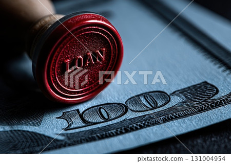 Close-up of a red rubber stamp labeled 'Loan' on a hundred dollar banknote 131004954