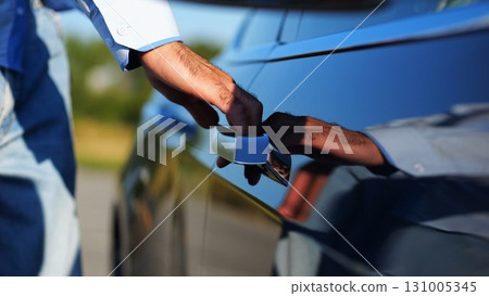 Close up to male hand of businessman opening door and getting in to modern electric car. Arm of entrepreneur opens door and sits down into the electrical auto. Young businessperson commuting to work Close up to male hand of businessman opening door and getting in to modern electric car. Arm of entrepreneur opens door and sits down into the electrical auto. Young businessperson commuting to work 131005345