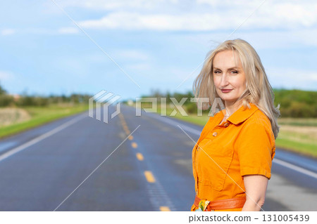 Blonde free woman is on the empty rural road in summer. Blonde free woman is on the empty rural road in summer. 131005439