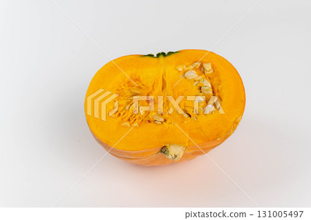 Pumpkin half showing orange flesh and raw seeds Pumpkin half showing orange flesh and raw seeds 131005497
