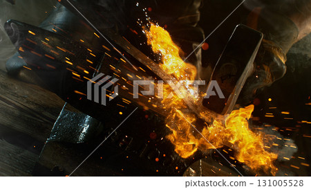 Close-up of blacksmith forging glowing hot iron on anvil with flying sparks Close-up of blacksmith forging glowing hot iron on anvil with flying sparks 131005528