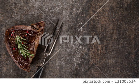 Beef rump steak on black stone table, top down, close-up. 131005534