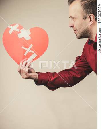 adult man holding broken heart 131005619