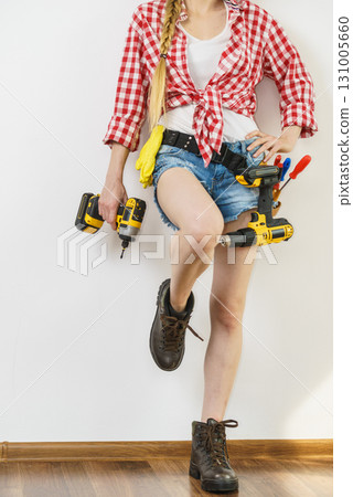 Woman with toolbelt and drill 131005660