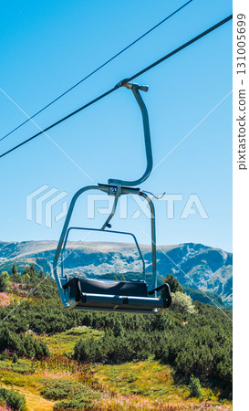 Chair Lift above the mountains and green forest of Bulgaria. Eco tourism. Tourist attraction. Seven Rila lakes. Cable car in the Rila Mountains Chair Lift above the mountains and green forest of Bulgaria. Eco tourism. Tourist attraction. Seven Rila lakes. Cable car in the Rila Mountains 131005699