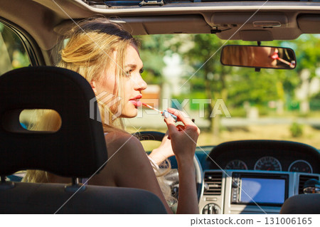 Girl apply make up while driving car. 131006165