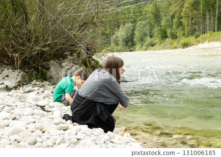 Children sitting on the coast near the river in the forest. Children sitting on the coast near the river in the forest. 131006185