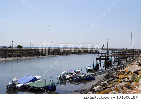 A traditional wooden boat moored at a pier on the riverbank near Aveiro, Portugal. Concept: tourism, sea travel, ecology A traditional wooden boat moored at a pier on the riverbank near Aveiro, Portugal. Concept: tourism, sea travel, ecology 131006187