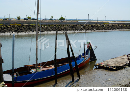 A traditional wooden boat moored at a pier on the riverbank near Aveiro, Portugal. Concept: tourism, sea travel, ecology A traditional wooden boat moored at a pier on the riverbank near Aveiro, Portugal. Concept: tourism, sea travel, ecology 131006188