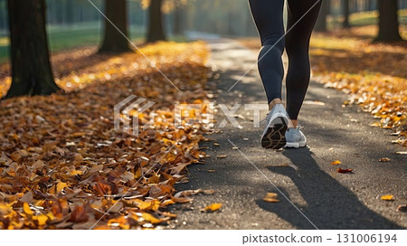 An athlete jogs in an autumn park among colorful leaves. Concept of men's fitness and a healthy lifestyle in nature. 131006194