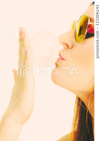 Funky girl blowing balloon. 131006242