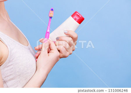 Woman holds toothbrush and paste for teeth cleaning 131006246