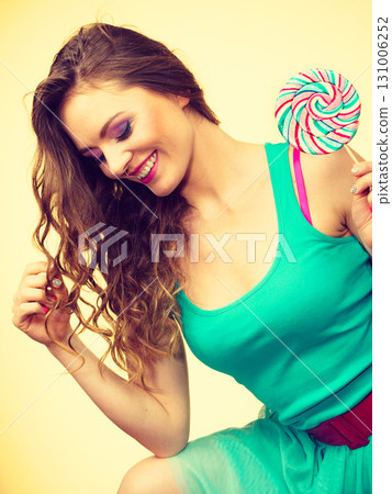 Woman charming girl with lollipop candy 131006252