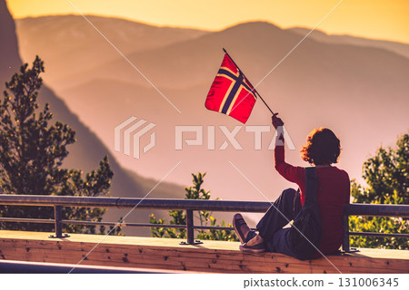 Tourist with norwegian flag and mountains landscape Tourist with norwegian flag and mountains landscape 131006345