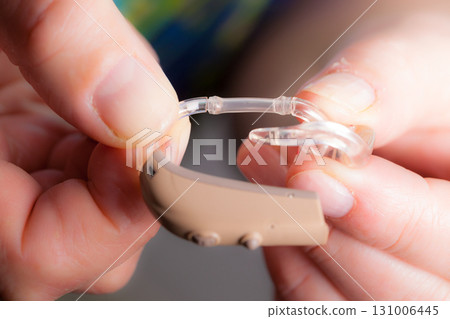 senior person holding hearing aid closeup 131006445